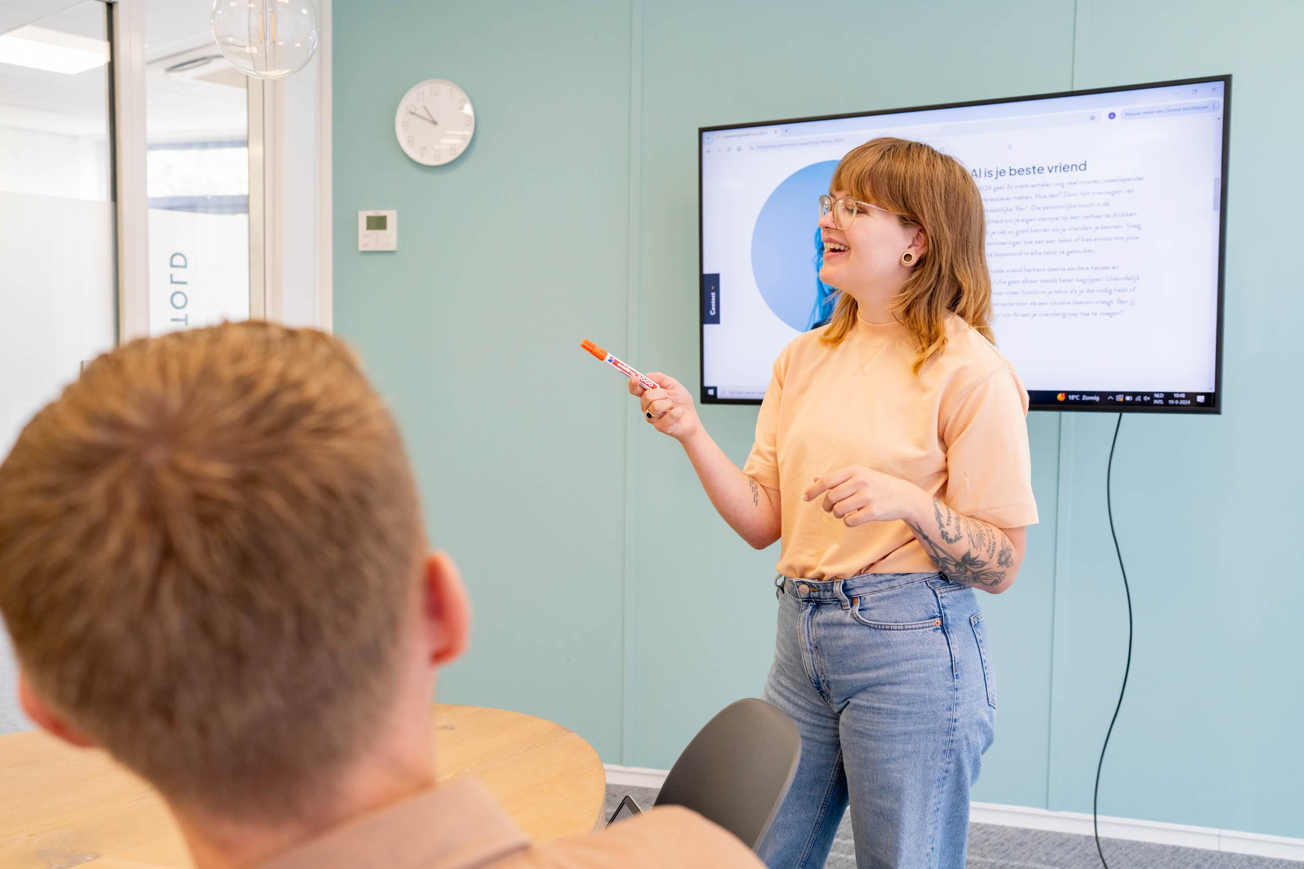 Vrouw geeft een presentatie met een scherm op de achtergrond