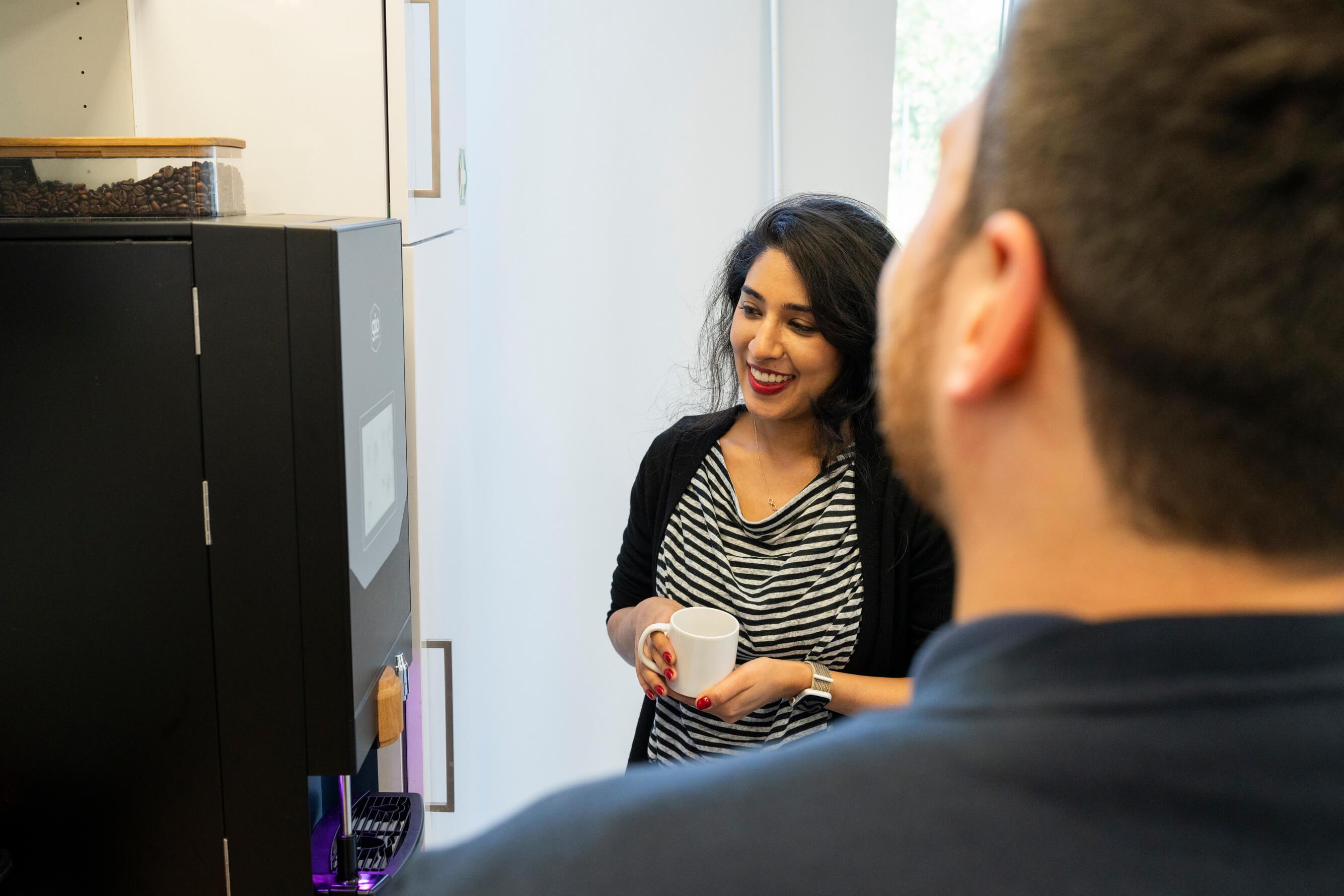 Twee collega's bij het koffiezetapparaat